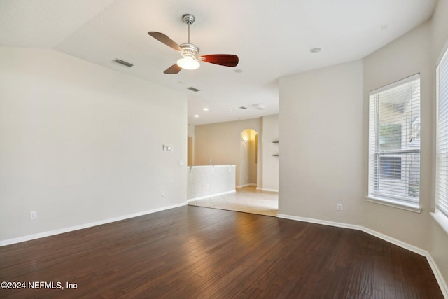 empty room featuring a wealth of natural light, hardwood / wood-style floors, and ceiling fan