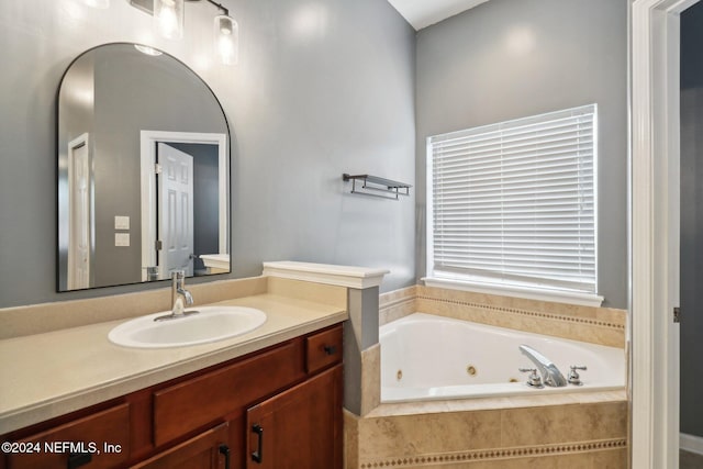 bathroom featuring vanity and a relaxing tiled tub