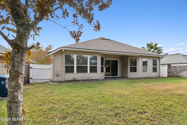 rear view of property with a lawn