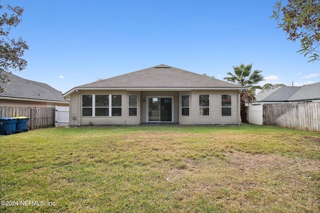 rear view of house featuring a lawn