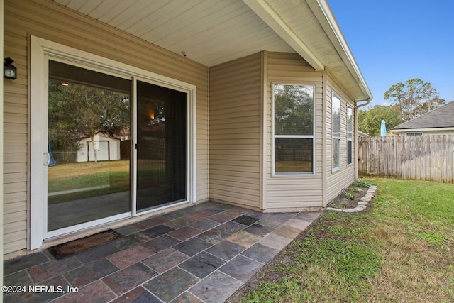 doorway to property with a patio area and a lawn