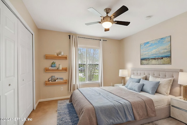 carpeted bedroom featuring ceiling fan and a closet