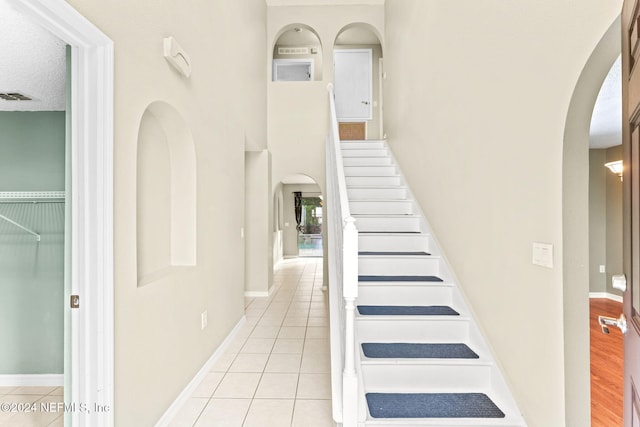 stairs featuring hardwood / wood-style floors and a textured ceiling