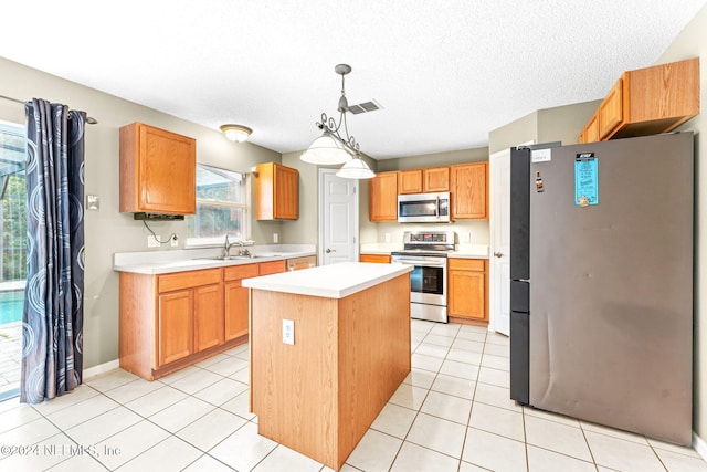 kitchen with a kitchen island, light tile patterned flooring, hanging light fixtures, and appliances with stainless steel finishes