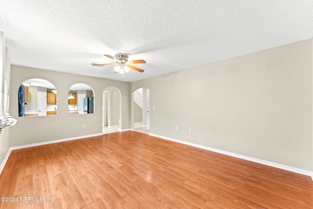 spare room featuring ceiling fan, light hardwood / wood-style floors, and a textured ceiling