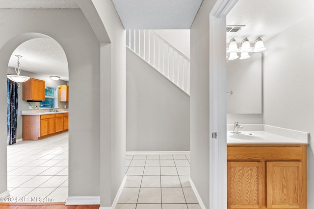 bathroom featuring tile patterned flooring, a textured ceiling, and vanity