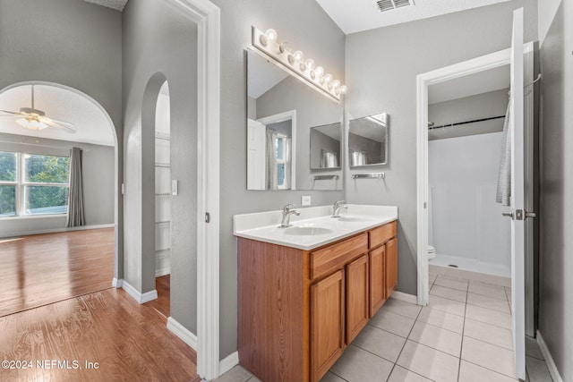 bathroom with hardwood / wood-style floors, vanity, ceiling fan, and a textured ceiling