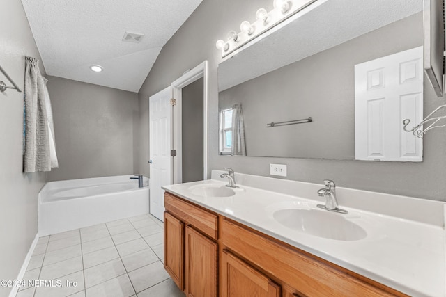 bathroom featuring vanity, lofted ceiling, a bath, tile patterned flooring, and a textured ceiling