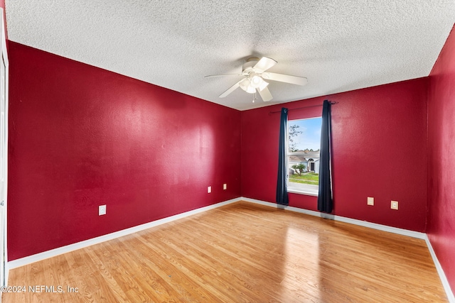 unfurnished room featuring hardwood / wood-style flooring, ceiling fan, and a textured ceiling