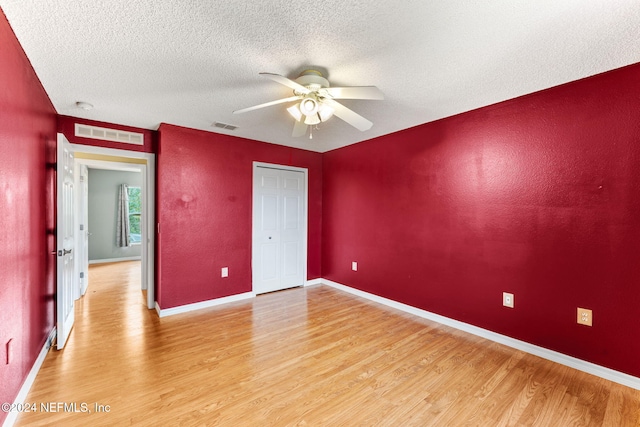 unfurnished bedroom with ceiling fan, a textured ceiling, and light hardwood / wood-style flooring