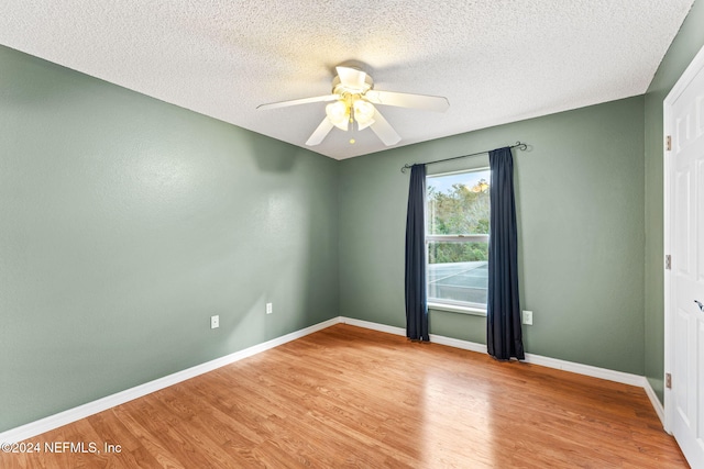 empty room featuring ceiling fan, a textured ceiling, and light hardwood / wood-style flooring