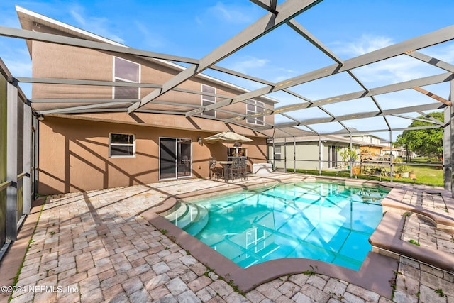 view of swimming pool with a patio area and a lanai