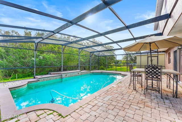 view of pool featuring glass enclosure and a patio area