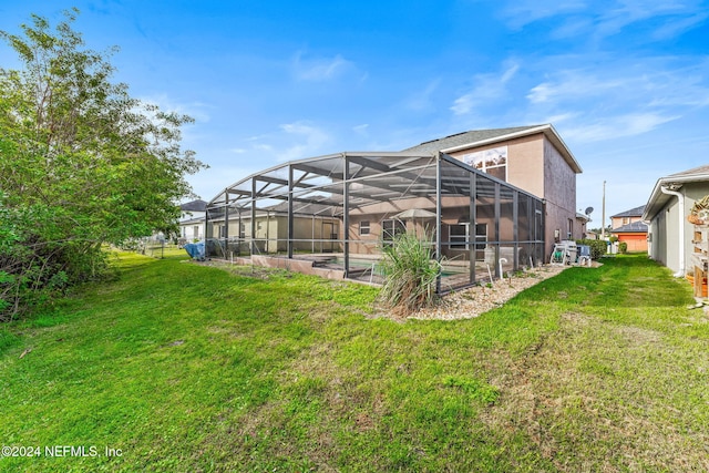 back of property with a lanai and a yard