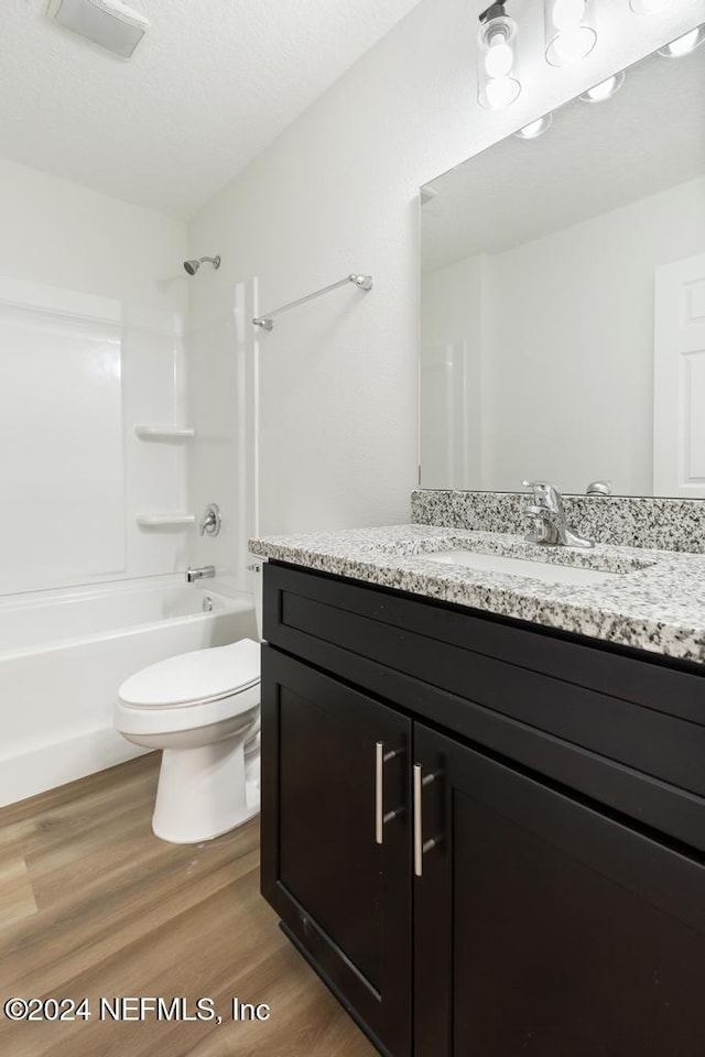 full bathroom with vanity, hardwood / wood-style flooring, toilet, and shower / washtub combination