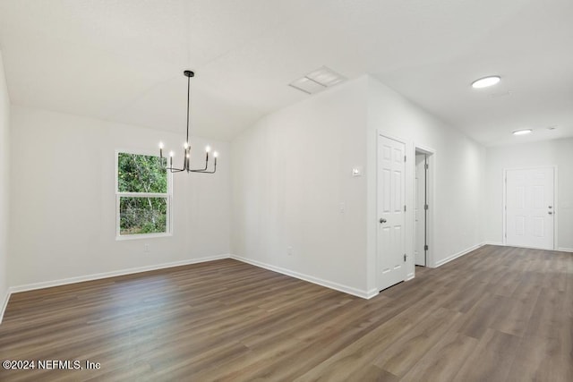 unfurnished room with vaulted ceiling, dark hardwood / wood-style flooring, and a chandelier