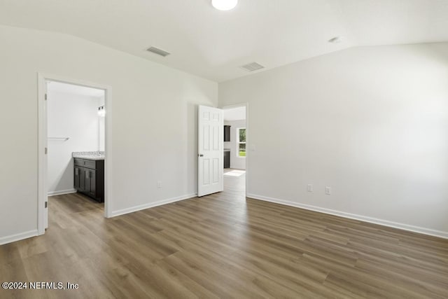 interior space with dark wood-type flooring and vaulted ceiling