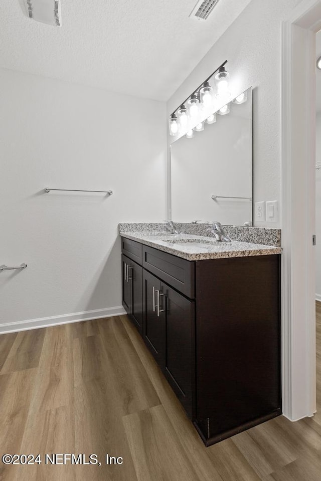 bathroom with vanity, a textured ceiling, and hardwood / wood-style flooring