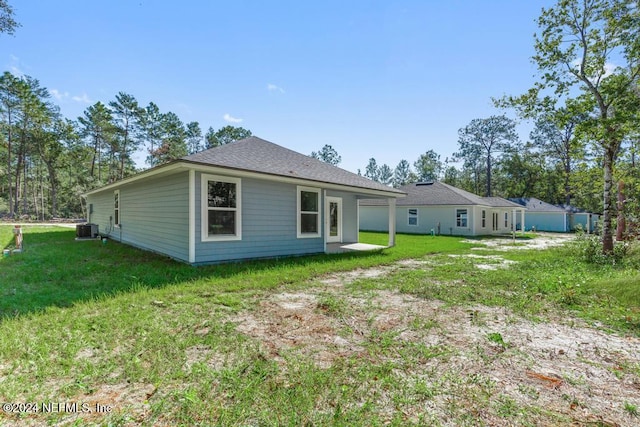 back of property featuring a lawn and central AC unit