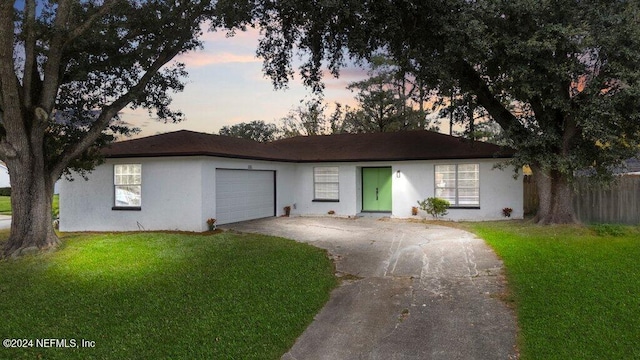 ranch-style house featuring a yard and a garage