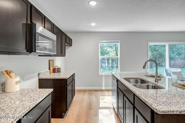 kitchen featuring a wealth of natural light, sink, a kitchen island with sink, and appliances with stainless steel finishes