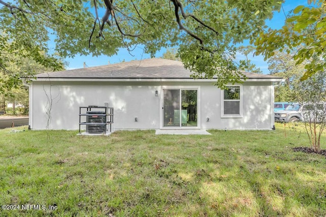 rear view of property featuring a lawn