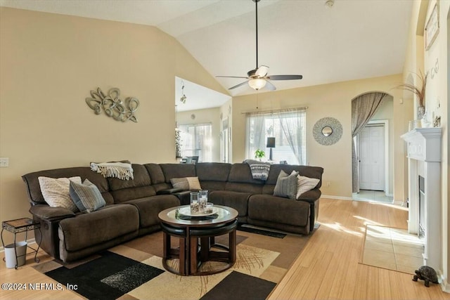 living room featuring ceiling fan, light hardwood / wood-style floors, and lofted ceiling