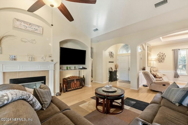 living room featuring ceiling fan, light hardwood / wood-style floors, and a fireplace