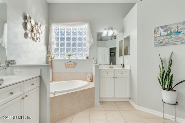 bathroom with tile patterned floors, vanity, and a relaxing tiled tub