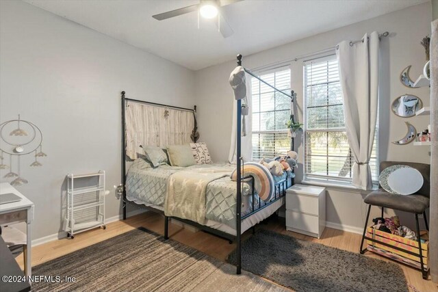 bedroom featuring multiple windows, hardwood / wood-style floors, and ceiling fan