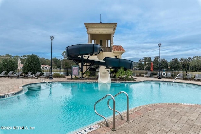 view of pool with a patio and a water slide