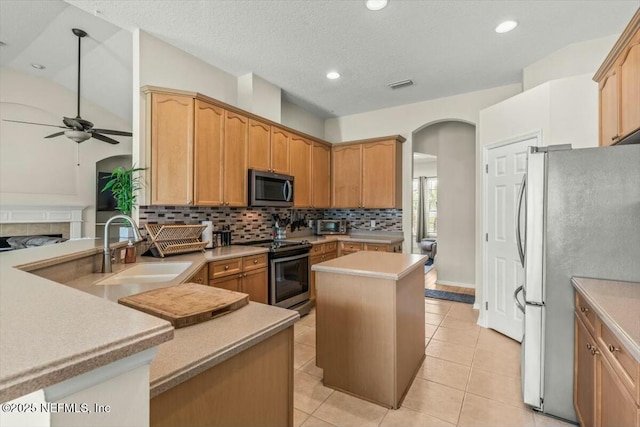 kitchen featuring a sink, stainless steel appliances, visible vents, arched walkways, and ceiling fan