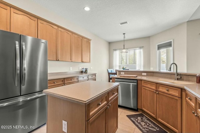 kitchen with a sink, a kitchen island, appliances with stainless steel finishes, light tile patterned floors, and visible vents