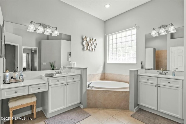 full bath with a sink, a garden tub, tile patterned flooring, and two vanities