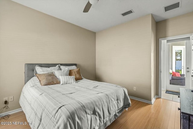 bedroom featuring baseboards, visible vents, and wood finished floors