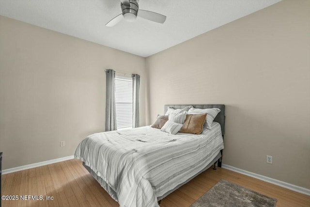 bedroom featuring a ceiling fan, baseboards, and wood finished floors