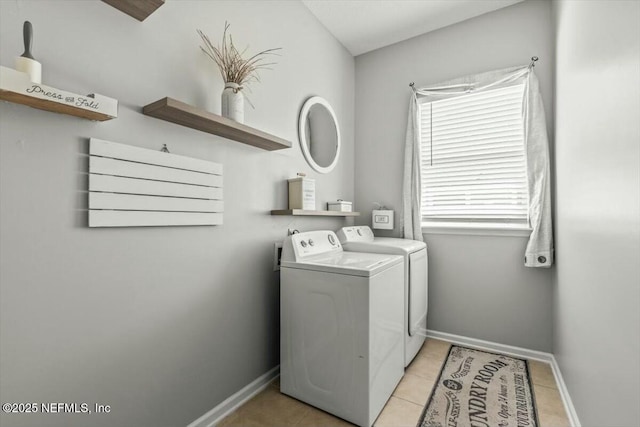clothes washing area featuring baseboards, separate washer and dryer, laundry area, and light tile patterned floors