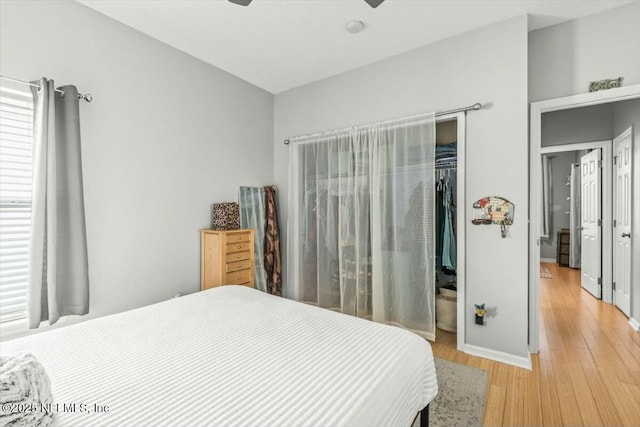 bedroom with a closet, light wood-style floors, and ceiling fan