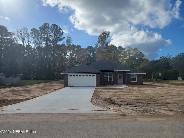 view of front of house featuring brick siding, driveway, and a garage