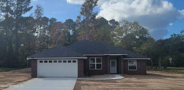 single story home featuring an attached garage, brick siding, driveway, and a shingled roof