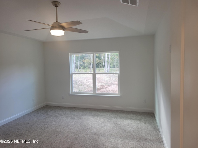 carpeted empty room with visible vents, ceiling fan, and baseboards