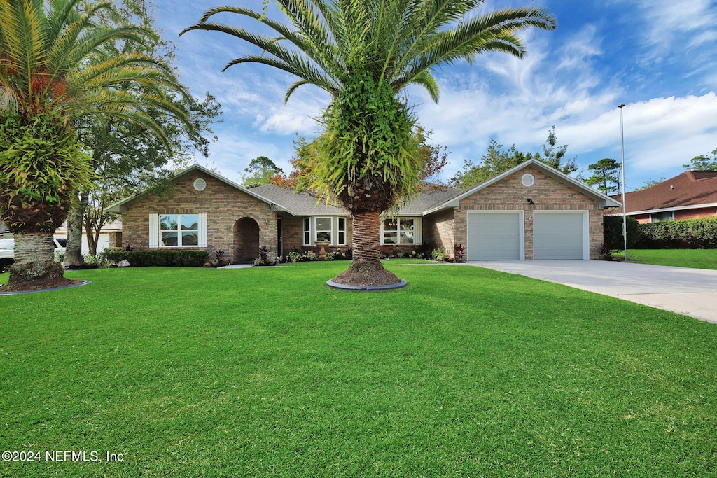 single story home featuring a front lawn and a garage