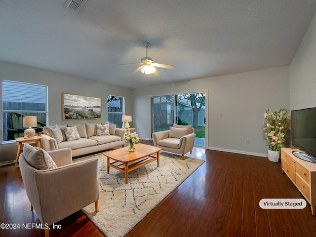 living room featuring ceiling fan and dark wood-type flooring