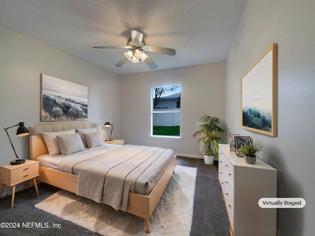 carpeted bedroom featuring ceiling fan and a textured ceiling