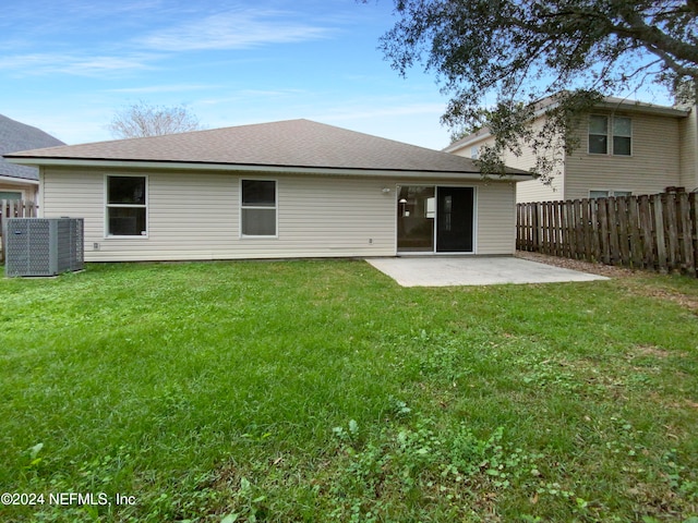 rear view of property featuring a yard, cooling unit, and a patio