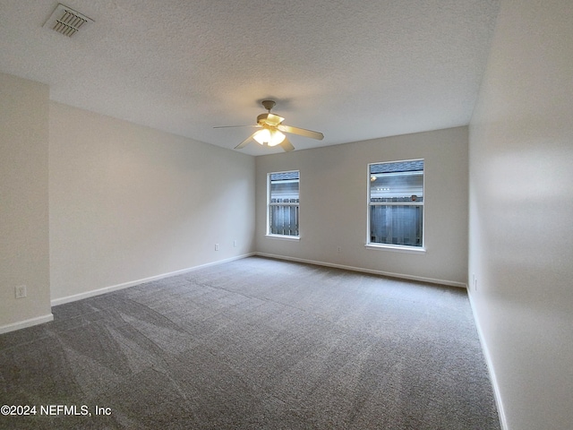 carpeted empty room with ceiling fan and a textured ceiling