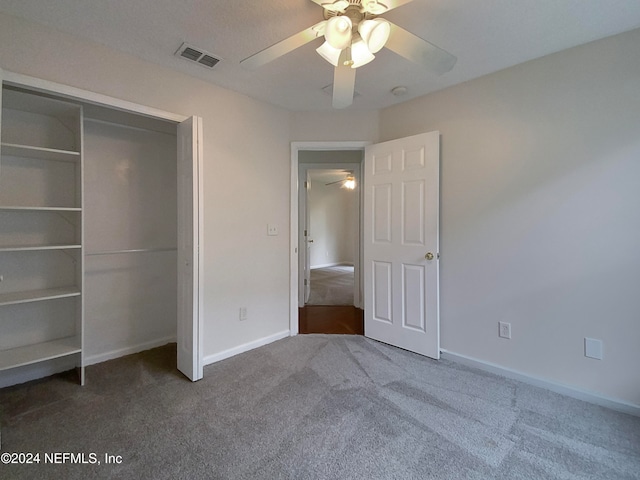 unfurnished bedroom featuring ceiling fan, a closet, and dark carpet