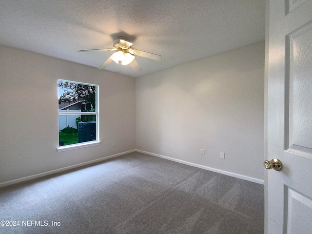 carpeted spare room featuring ceiling fan and a textured ceiling