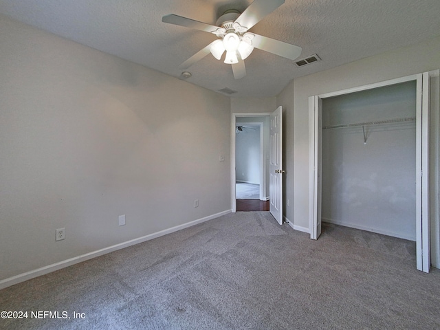 unfurnished bedroom with carpet flooring, ceiling fan, a closet, and a textured ceiling