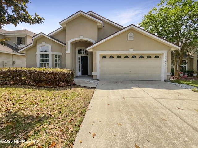 1421 Woodland View Dr, Fleming Island, FL 32003 - view of front facade with a garage, driveway, and stucco siding